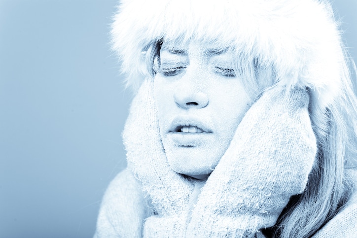Cold Female Holding her Face Which is Covered in Ice