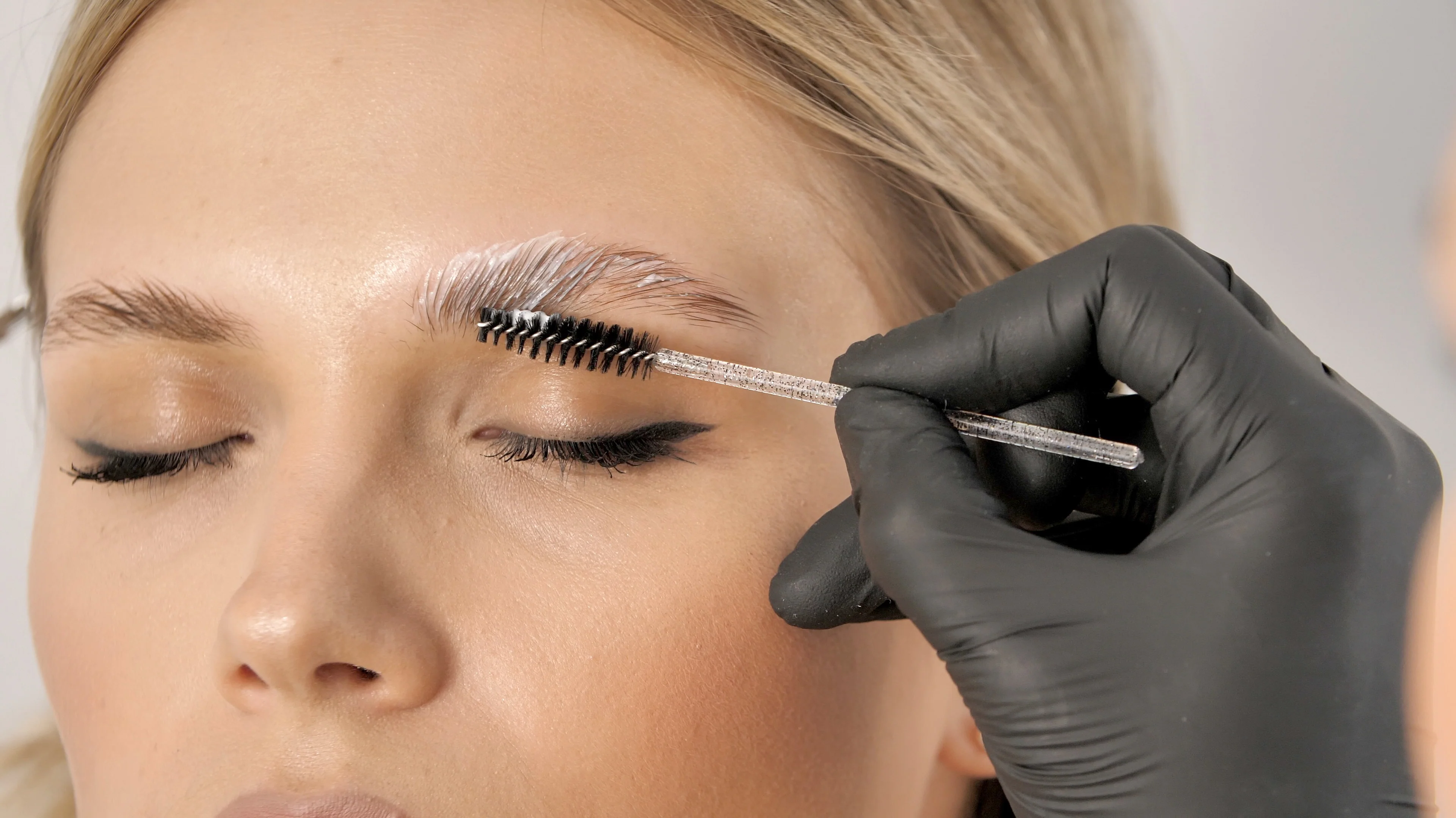 Brow artist applying solution during lamination process