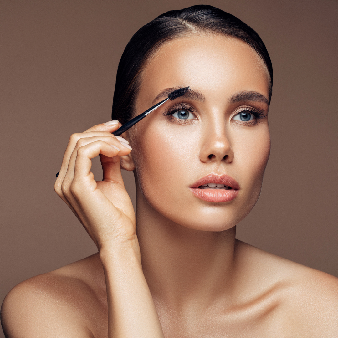 Woman brushing brows with spool brush following brow lamination.