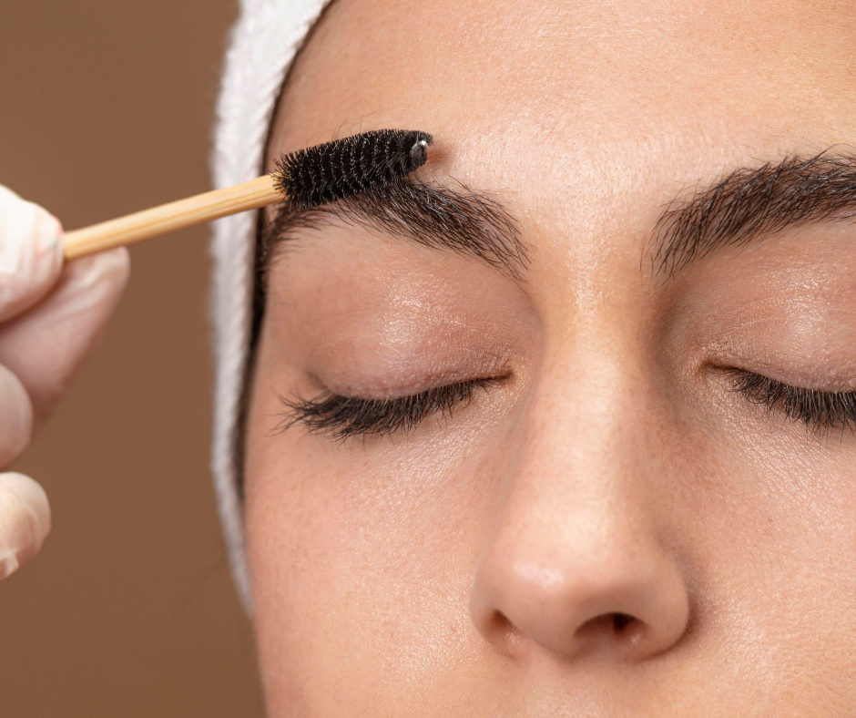 Brow expert using spoolie brush to brush beautiful brows